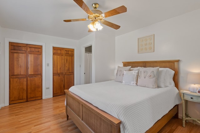 bedroom featuring two closets, a ceiling fan, and light wood-style floors