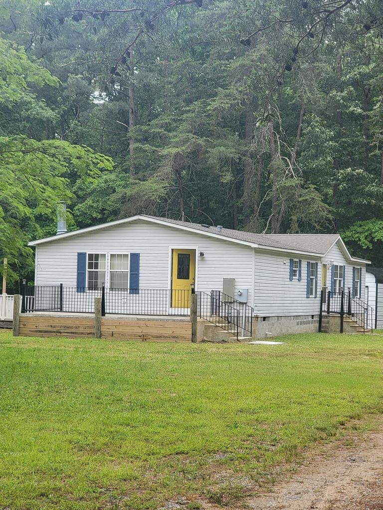 159 Dirt Bridge Rd, Topping, VA 23169 - view of front facade with crawl space, a front yard, and a view of trees