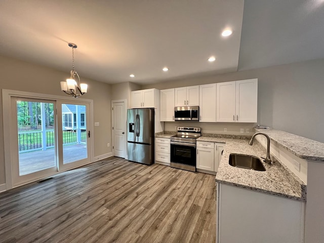 366 N Glebe Rd, Montross, VA 22520 - kitchen featuring appliances with stainless steel finishes, a sink, light wood-type flooring, light stone countertops, and a peninsula