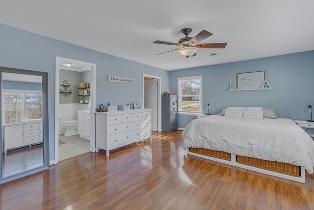 bedroom featuring connected bathroom, ceiling fan, and light hardwood / wood-style flooring