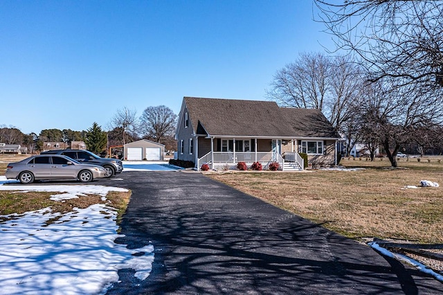 view of front facade with covered porch, a garage, an outdoor structure, and a front yard