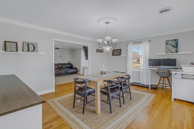 dining space with a chandelier, light hardwood / wood-style floors, and ornamental molding