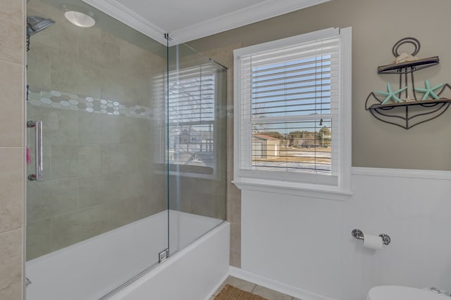 bathroom featuring tile patterned floors, toilet, ornamental molding, and bath / shower combo with glass door