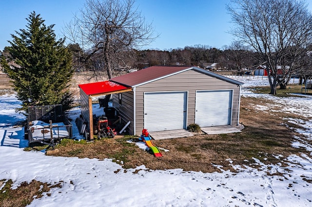 snow covered structure with a garage