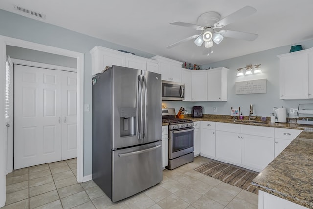 kitchen with appliances with stainless steel finishes, ceiling fan, sink, light tile patterned floors, and white cabinets