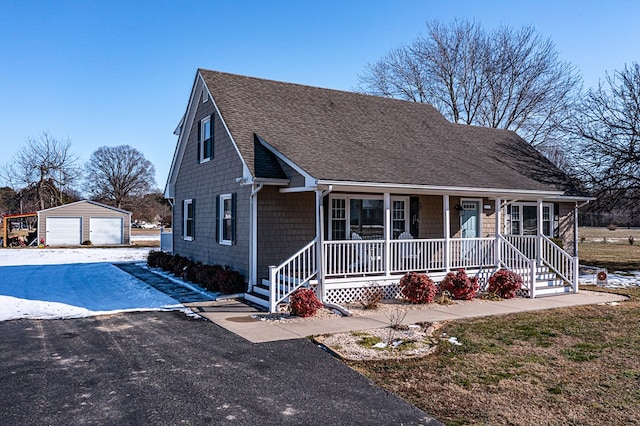 view of front facade featuring an outbuilding, a porch, and a garage