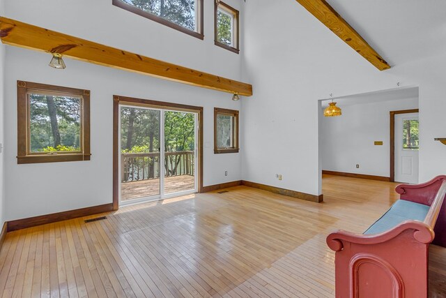 912 Levelgreen Rd, Lancaster, VA 22503 - living area featuring wood-type flooring, healthy amount of natural light, beam ceiling, and a towering ceiling