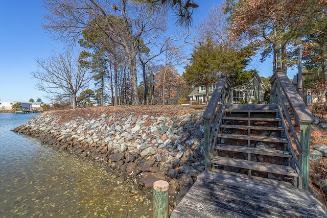 exterior space with a water view and stairs