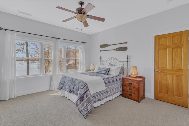 bedroom featuring light carpet, a ceiling fan, and baseboards