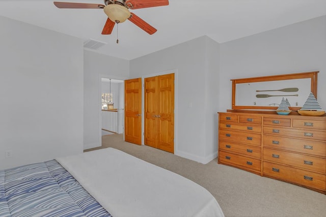 bedroom featuring baseboards, visible vents, carpet flooring, and ceiling fan with notable chandelier