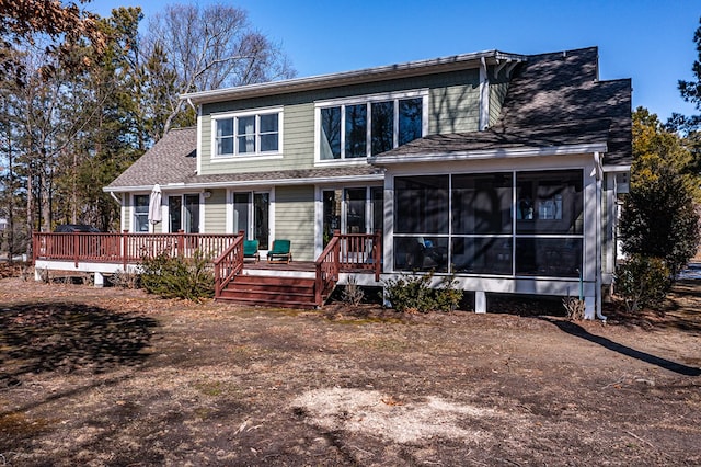 view of front of home with a sunroom, a deck, and roof with shingles