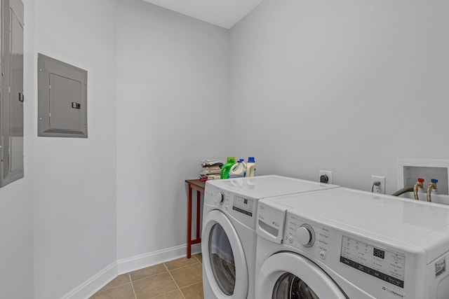 laundry area featuring washing machine and clothes dryer, light tile patterned floors, laundry area, electric panel, and baseboards