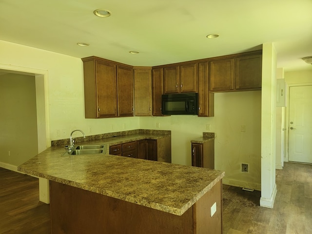 31 Moccasin Trl, Weems, VA 22576 - kitchen with black microwave, a peninsula, dark wood finished floors, recessed lighting, and dark countertops