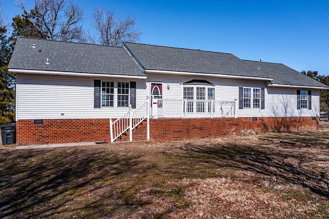 view of front of house featuring a shingled roof, a front yard, and crawl space