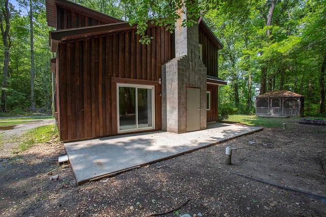 63 Pioneer Trl, Hague, VA 22469 - back of property with a patio area and board and batten siding