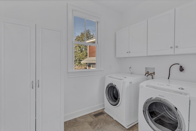 laundry room featuring visible vents, separate washer and dryer, cabinet space, and baseboards