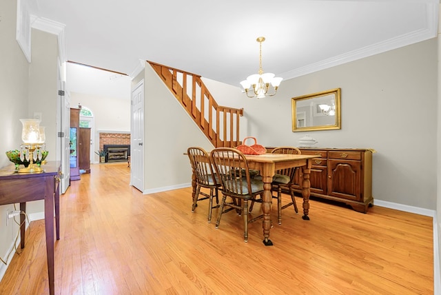 10 Heatherfield Ct, Kilmarnock, VA 22482 - dining space with a chandelier, light wood-type flooring, stairs, ornamental molding, and a brick fireplace