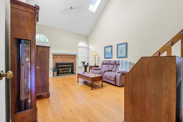 10 Heatherfield Ct, Kilmarnock, VA 22482 - living area with high vaulted ceiling, a skylight, light wood-type flooring, and a fireplace
