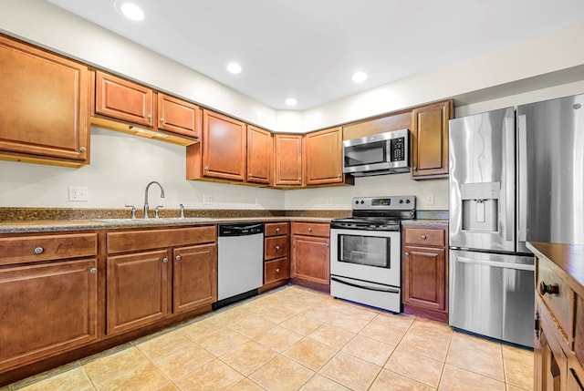 10 Heatherfield Ct, Kilmarnock, VA 22482 - kitchen with appliances with stainless steel finishes, dark countertops, brown cabinetry, recessed lighting, and light tile patterned floors