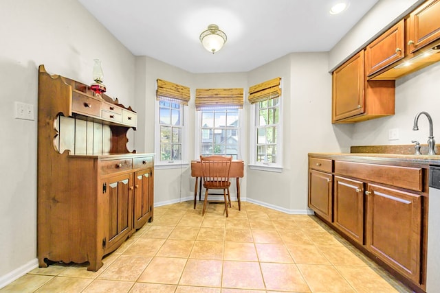 10 Heatherfield Ct, Kilmarnock, VA 22482 - kitchen with light tile patterned floors, brown cabinets, and dishwashing machine