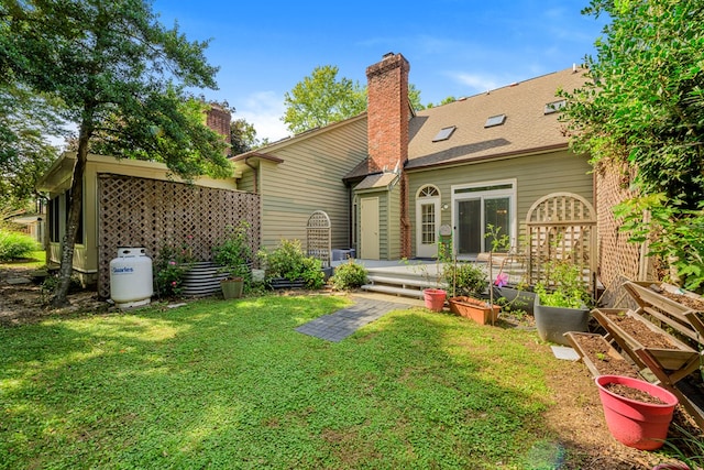10 Heatherfield Ct, Kilmarnock, VA 22482 - rear view of property featuring a lawn, a vegetable garden, and a chimney