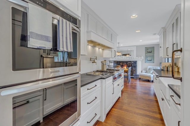 1083 Ottoman Ferry Rd, Lancaster, VA 22503 - kitchen with a fireplace, dark countertops, appliances with stainless steel finishes, white cabinets, and recessed lighting