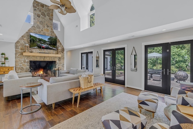 1083 Ottoman Ferry Rd, Lancaster, VA 22503 - living room featuring french doors, dark wood-style floors, a stone fireplace, ceiling fan, and a towering ceiling