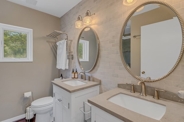 1083 Ottoman Ferry Rd, Lancaster, VA 22503 - bathroom with two vanities, backsplash, tile walls, and toilet