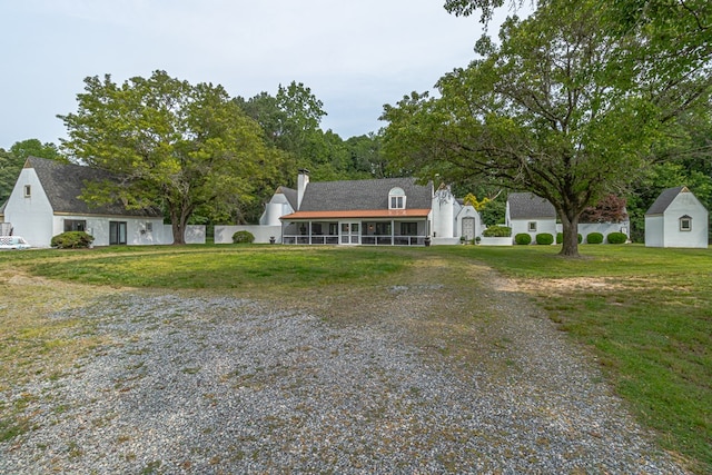 1083 Ottoman Ferry Rd, Lancaster, VA 22503 - view of front of house with a front yard, gravel driveway, a sunroom, and a chimney
