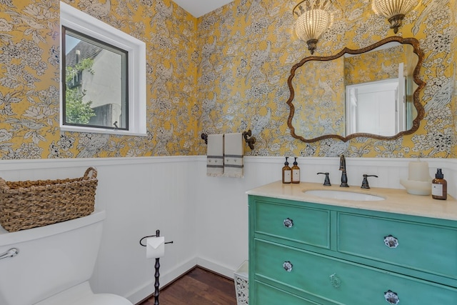 1083 Ottoman Ferry Rd, Lancaster, VA 22503 - bathroom featuring a wainscoted wall, wood finished floors, vanity, wallpapered walls, and toilet