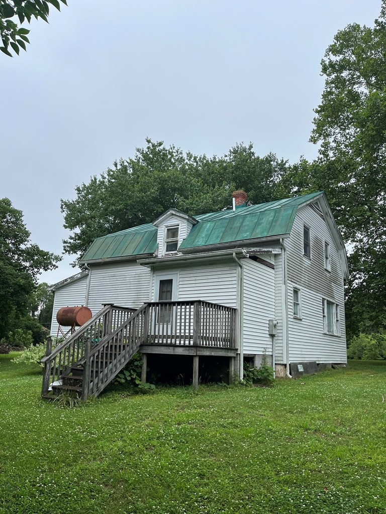 425 Kingston Rd, Heathsville, VA 22511 - back of house featuring a wooden deck, a lawn, a metal roof, and a chimney