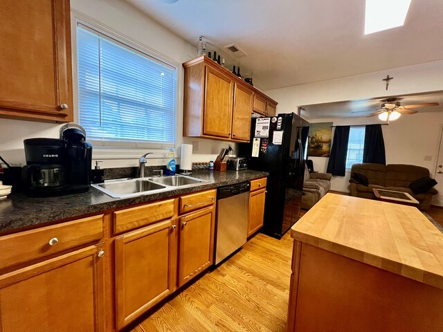 701 Lewis St, Tappahannock, VA 22560 - kitchen with stainless steel dishwasher, butcher block countertops, open floor plan, light wood finished floors, and brown cabinets