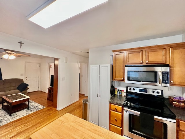 701 Lewis St, Tappahannock, VA 22560 - kitchen with appliances with stainless steel finishes, light wood-type flooring, brown cabinetry, and open floor plan