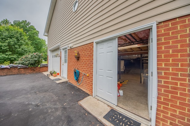1851 Desha Rd, Tappahannock, VA 22560 - view of exterior entry featuring brick siding and a garage