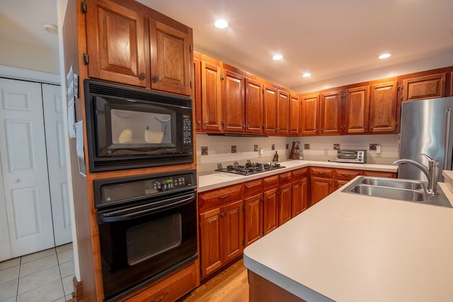 1851 Desha Rd, Tappahannock, VA 22560 - kitchen featuring black appliances, a sink, light countertops, brown cabinets, and recessed lighting