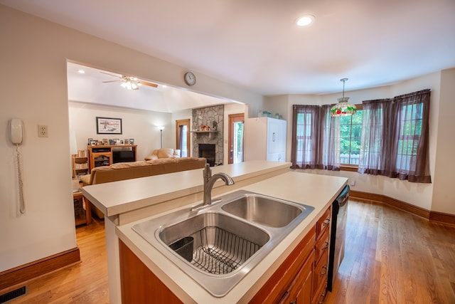 1851 Desha Rd, Tappahannock, VA 22560 - kitchen featuring a sink, a fireplace, brown cabinets, a kitchen island with sink, and open floor plan