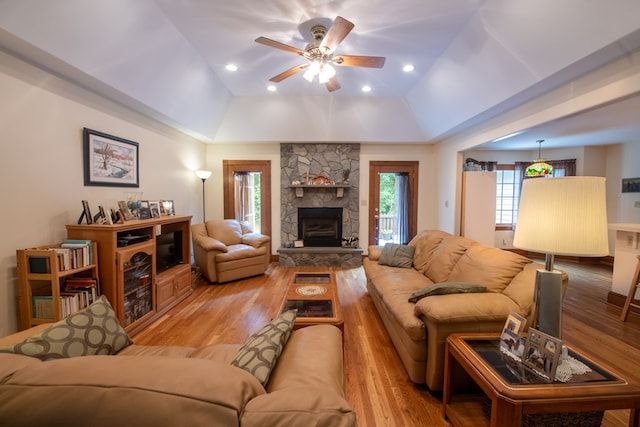 1851 Desha Rd, Tappahannock, VA 22560 - living room featuring a ceiling fan, light wood-type flooring, vaulted ceiling, a fireplace, and a tray ceiling