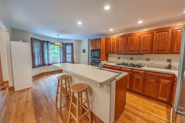 1851 Desha Rd, Tappahannock, VA 22560 - kitchen featuring black appliances, a sink, light countertops, a breakfast bar area, and recessed lighting