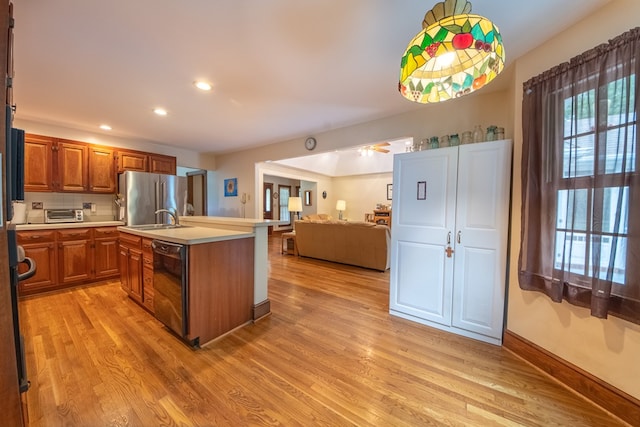 1851 Desha Rd, Tappahannock, VA 22560 - kitchen with freestanding refrigerator, a sink, light wood finished floors, brown cabinetry, and black dishwasher