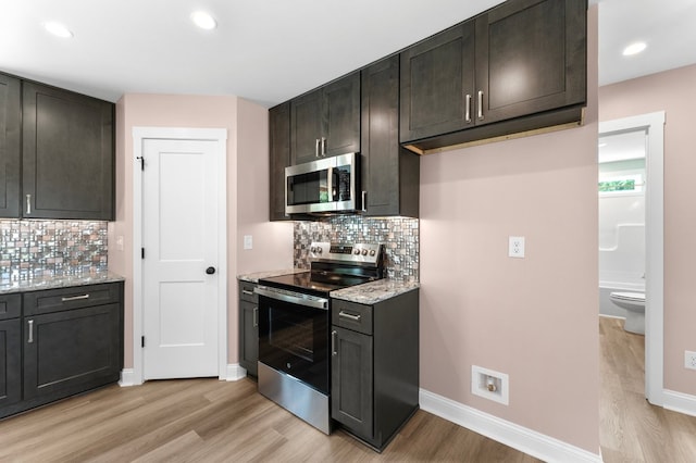 2976 Newmans Neck Rd, Heathsville, VA 22473 - kitchen with appliances with stainless steel finishes, light wood finished floors, tasteful backsplash, light stone countertops, and baseboards