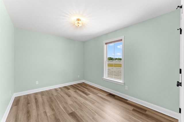 2976 Newmans Neck Rd, Heathsville, VA 22473 - spare room featuring wood finished floors, baseboards, and a barn door