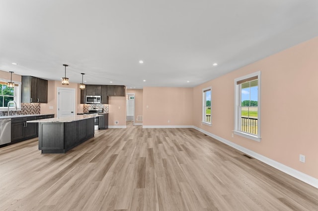 2976 Newmans Neck Rd, Heathsville, VA 22473 - kitchen featuring stainless steel appliances, backsplash, light wood-style flooring, a sink, and baseboards