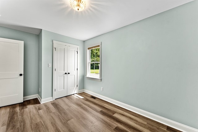 2976 Newmans Neck Rd, Heathsville, VA 22473 - unfurnished bedroom featuring baseboards, wood finished floors, and a closet