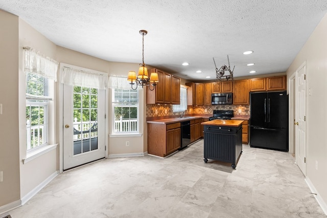 135 Hobbs Hole Ln, Tappahannock, VA 22560 - kitchen with black appliances, a chandelier, backsplash, healthy amount of natural light, and a textured ceiling