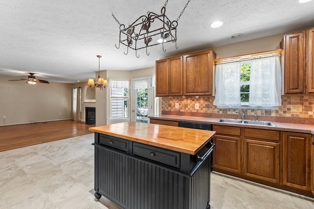 135 Hobbs Hole Ln, Tappahannock, VA 22560 - kitchen with wooden counters, a chandelier, a textured ceiling, plenty of natural light, and decorative backsplash