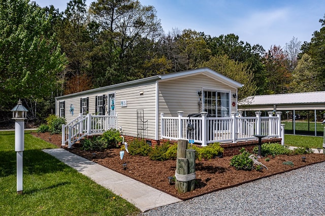 manufactured / mobile home with crawl space, a wooden deck, and a front yard