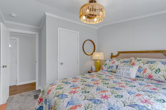 bedroom featuring visible vents, carpet floors, a chandelier, and ornamental molding