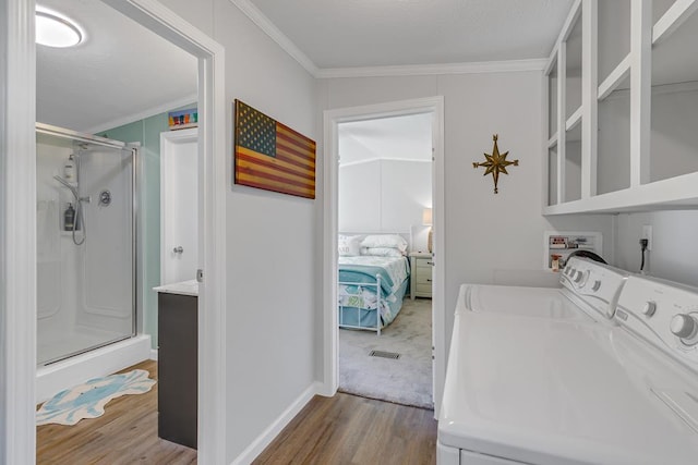 laundry area with separate washer and dryer, wood finished floors, laundry area, and crown molding