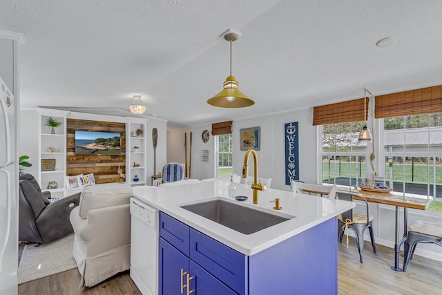 kitchen with blue cabinets, a sink, white dishwasher, light wood-type flooring, and open floor plan