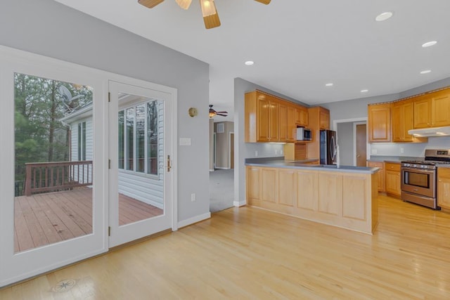 kitchen featuring ceiling fan, appliances with stainless steel finishes, kitchen peninsula, and light hardwood / wood-style floors